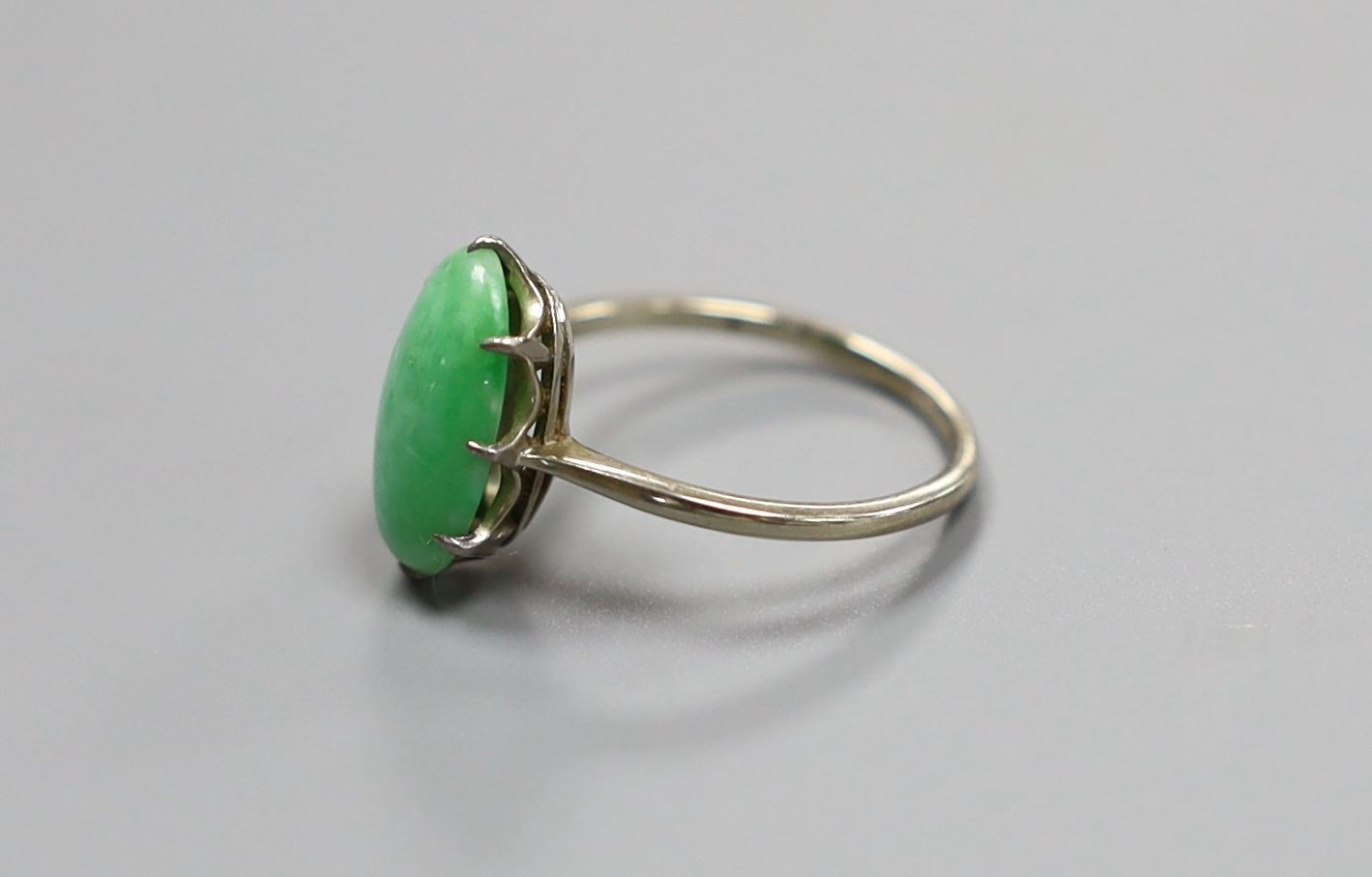 A white metal and oval cabochon jade set ring, size L, gross 2.4 grams.